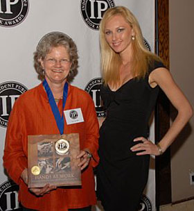 Iris Graville (left) accepts the Independent Publisher award from the IPPY presenter.