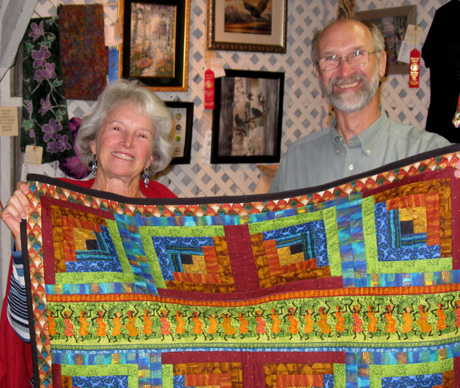 Midge Paterson shows off the quilt with a beaming Dick Coffey...