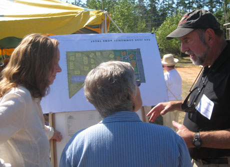 Home Trust board member Larry Soll (right) explains the plan to neighbors at Saturday's event.