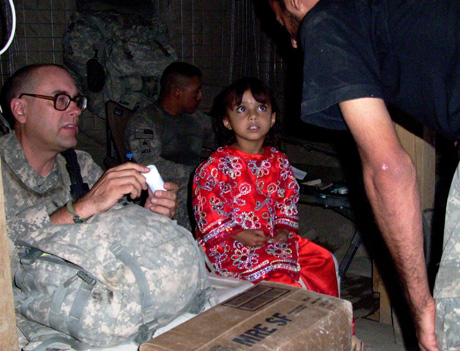 Sgt. Bauschke helps a little girl in Afghanistan....