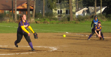 Kerri Goff fires it for the Wolverines as Maggie Anderson at first base watches....