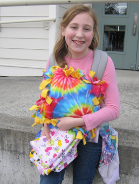 That's Isabella with a colorful pillow she just made yesterday in Kay Kohler's after-school sewing class - looks good!