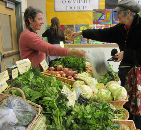 Liz gets her week's veggies from Blue Moon Farm's offerings at last weekend's Farmers' Market...the Market moves outside for the season (till the end of October) on the 17th this month.