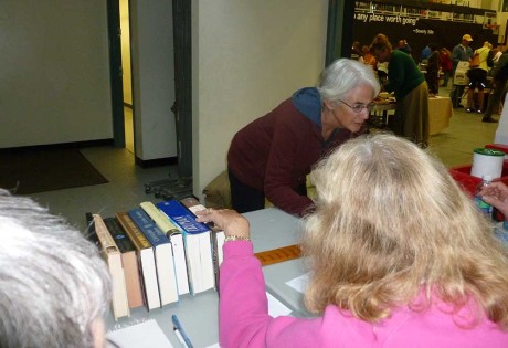 This is a picture from last year's book sale, showing a cashier measuring books to charge by the inch
