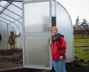 Marty Ahart of the Community Gardens in red, and inside, bracing a wall support, Bequin Lapwing, who started the community garden in the first place - Update staff photo